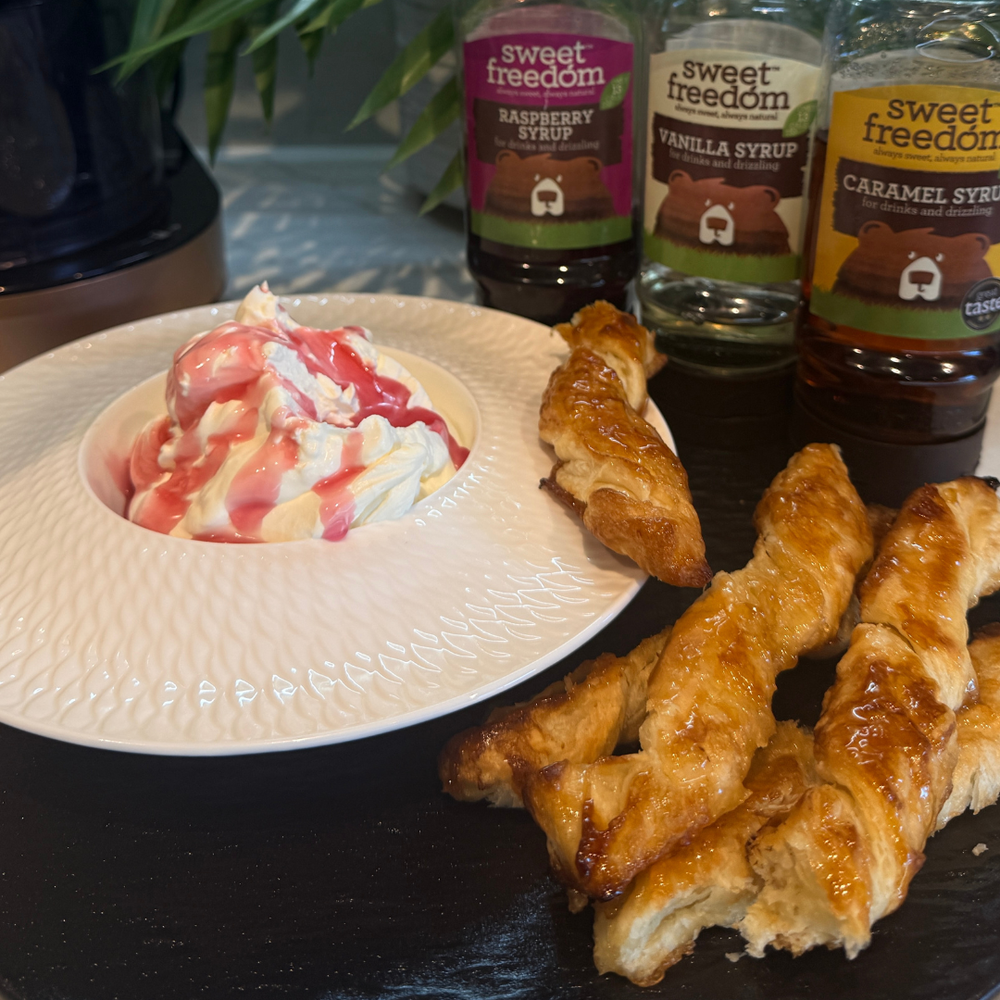 A line up of Sweet Freedom Syrups used in this vegan cream horn twist recipe, showing the naturally flavoured cream in a white plate and the vegan pastry horns to dip