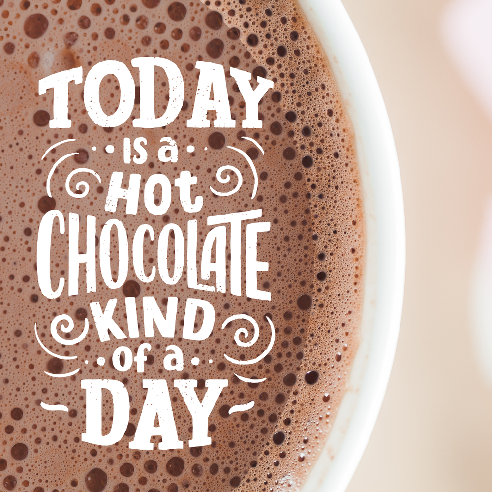 Close up image from above of a hot chocolate in a white mug with swirly writing saying 'today is a hot chocolate kind of day' over the chocolatey foam