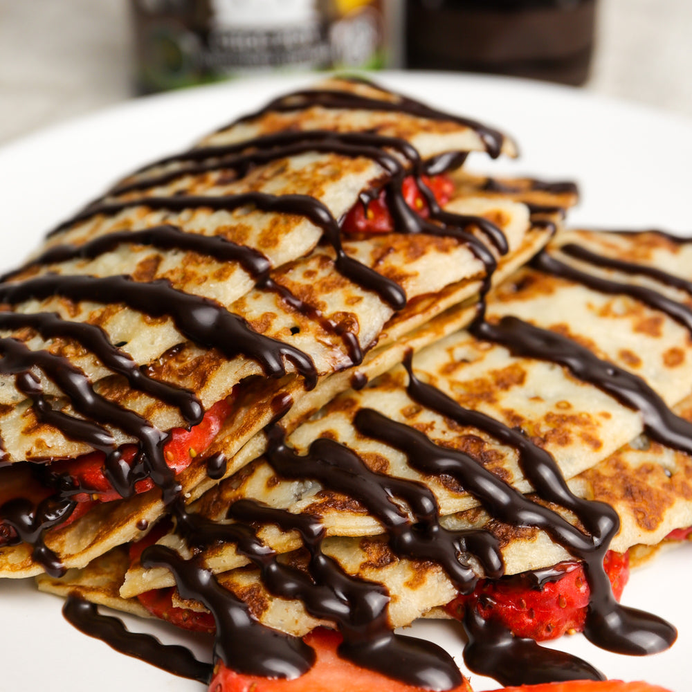 Crepes with strawberries drizzled in CHOC SHOT