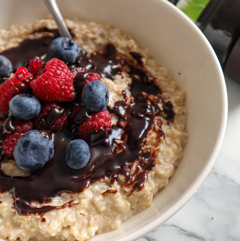 Porridge with blueberries, raspberries and a drizzle of CHOC SHOT Salted Caramel