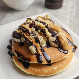 Pancakes with banana, nuts and a drizzle of CHOC SHOT Salted Caramel